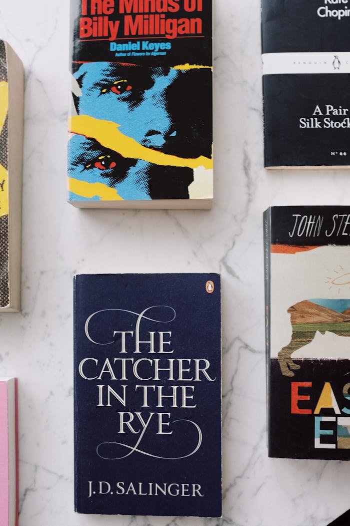 Top view of composed famous books with colorful covers placed in rows on white marble table